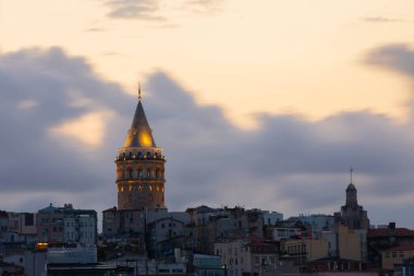 İstanbul 'daki Galata Kulesi' nin akşam görüntüsü. Gökyüzü manzaralı altın saat ve güzel güneş ışığı.