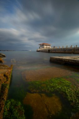 İstanbul 'da bulutlu ve rüzgarlı bir günde Moda rıhtımının dramatik uzun pozlama manzarası