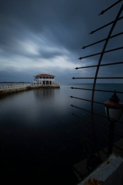 İstanbul 'da bulutlu ve rüzgarlı bir günde Moda rıhtımının dramatik uzun pozlama manzarası