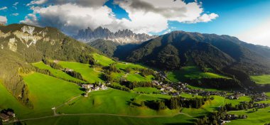 Val di Funes 'daki güzel küçük köyün havadan görünüşü, İtalya' daki Dolomite Alpleri 'ndeki kilise ve dağlarla.