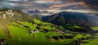 Val di Funes 'daki güzel küçük köyün havadan görünüşü, İtalya' daki Dolomite Alpleri 'ndeki kilise ve dağlarla.