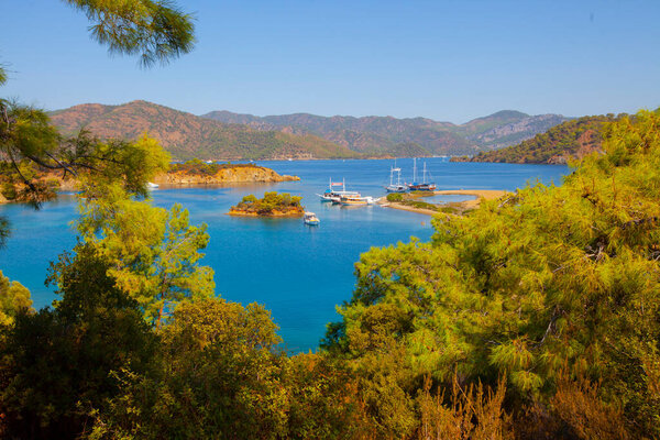Beautiful flowers can be seen past the Lighthouse at Ortakent in Turkey with blue/green seas stretching to the horizon