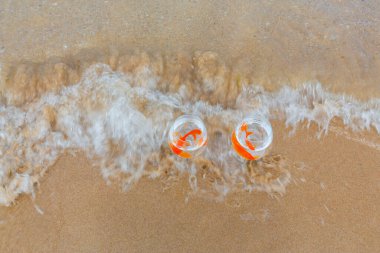 Denizde küçük akvaryumlar ve balıklar.