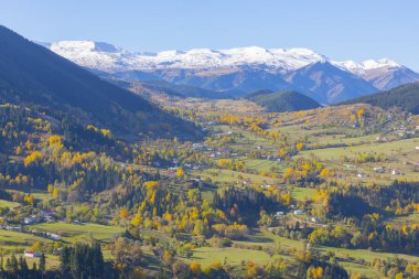 Savsat Bölgesi 'nde sonbahar sezonu. Artvin, Türkiye. Yavuzkoy Platosu 'ndan güzel bir sonbahar manzarası. Karlı dağ arkaplanlı renkli doğa manzarası.