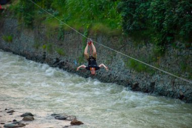 Firtina Nehri üzerinde çelik halatla kayma sporu yapan turist Camlihemsin, Rize, Türkiye 'de eğleniyor.