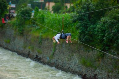 Firtina Nehri üzerinde çelik halatla kayma sporu yapan turist Camlihemsin, Rize, Türkiye 'de eğleniyor.