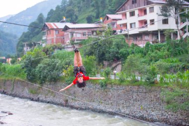 Firtina Nehri üzerinde çelik halatla kayma sporu yapan turist Camlihemsin, Rize, Türkiye 'de eğleniyor.