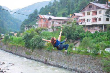Firtina Nehri üzerinde çelik halatla kayma sporu yapan turist Camlihemsin, Rize, Türkiye 'de eğleniyor.