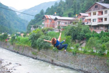 Firtina Nehri üzerinde çelik halatla kayma sporu yapan turist Camlihemsin, Rize, Türkiye 'de eğleniyor.