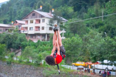 Firtina Nehri üzerinde çelik halatla kayma sporu yapan turist Camlihemsin, Rize, Türkiye 'de eğleniyor.