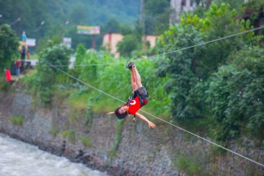 Firtina Nehri üzerinde çelik halatla kayma sporu yapan turist Camlihemsin, Rize, Türkiye 'de eğleniyor.