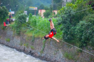 Firtina Nehri üzerinde çelik halatla kayma sporu yapan turist Camlihemsin, Rize, Türkiye 'de eğleniyor.