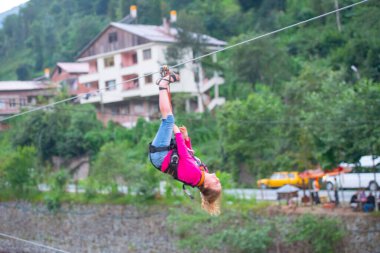 Firtina Nehri üzerinde çelik halatla kayma sporu yapan turist Camlihemsin, Rize, Türkiye 'de eğleniyor.