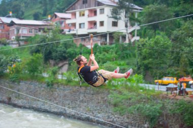 Firtina Nehri üzerinde çelik halatla kayma sporu yapan turist Camlihemsin, Rize, Türkiye 'de eğleniyor.