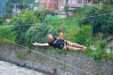 Firtina Nehri üzerinde çelik halatla kayma sporu yapan turist Camlihemsin, Rize, Türkiye 'de eğleniyor.