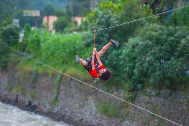 Firtina Nehri üzerinde çelik halatla kayma sporu yapan turist Camlihemsin, Rize, Türkiye 'de eğleniyor.