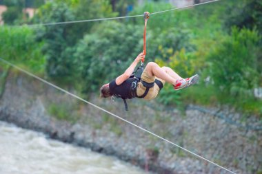 Firtina Nehri üzerinde çelik halatla kayma sporu yapan turist Camlihemsin, Rize, Türkiye 'de eğleniyor.