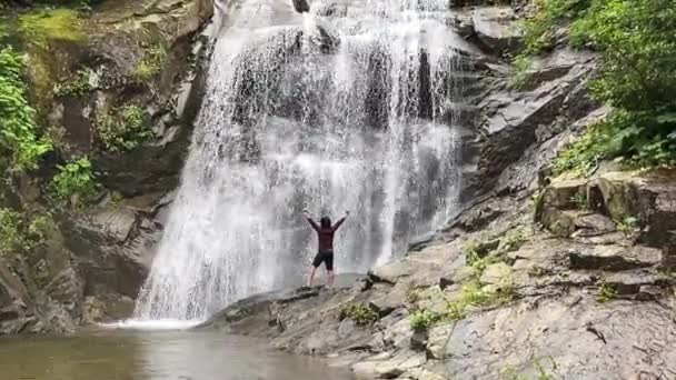 在瀑布下表现出力量的男人 — 图库视频影像