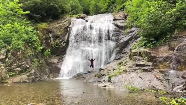 滝の下でリラックス力を示す男 — ストック動画