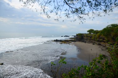 Tanah Lot Bali sahilinin güzel manzarası Pura Batu Bolong tapınağı manzaralı Tanah Lot Bali 'de bir sahil manzaralı Pura Batu Bolong tapınağı