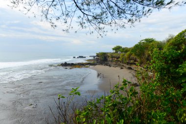 Tanah Lot Bali sahilinin güzel manzarası Pura Batu Bolong tapınağı manzaralı Tanah Lot Bali 'de bir sahil manzaralı Pura Batu Bolong tapınağı