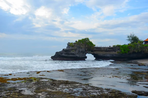 印度尼西亚Pura Batu Bolong自然岩洞的形成和日落时的波浪 — 图库照片