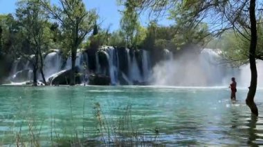 Bosna 'da bir nehre dökülen ormanlarla çevrili güzel Kravica şelalesi.