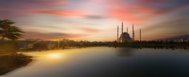 Sabancı Merkez Camii, Adana'da Eski Saat Kulesi ve Taş Köprü. Seyhan Nehri önünde cami minareleri ile Adana Belediyesi.