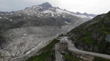 Manzaralı yolun hava aracı görüntüsü, Furka Geçidi 'ndeki Belvedere Oteli, İsviçre Alpleri' nin ünlü simgesi. İsviçre yaz turizm beldesi.