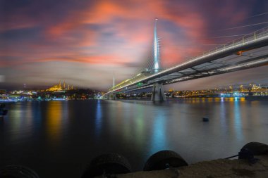 Yaz gecesi Yeni Haliç Metro Köprüsü İstanbul, Türkiye 'de mavi gökyüzü ve kent ışıkları