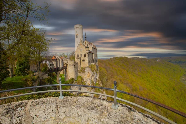 stock image Lichtenstein Castle on mountain top in summer, Germany, Europe. This famous castle is landmark of Schwarzwald, Baden-Wurttemberg. Scenic view of fairytale Lichtenstein Castle and city in distance.