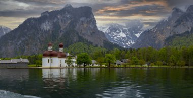 Konigsee Gölü, Berchtesgaden bölgesi, güney Bavyera, Almanya. Kırmızı soğan kubbeli St. Bartholomew Kilisesi. Renkli yapraklı sonbahar sahnesi, Alp Gölü ve Watzmann Dağı