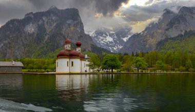 Konigsee Gölü, Berchtesgaden bölgesi, güney Bavyera, Almanya. Kırmızı soğan kubbeli St. Bartholomew Kilisesi. Renkli yapraklı sonbahar sahnesi, Alp Gölü ve Watzmann Dağı