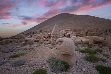 Zeus, Apollo, Herkül ve Aslan 'ın oyulmuş kadim başları, Türkiye' nin güneydoğusundaki antik Commagene Krallığı 'nın arkeolojik bir alanı olan Nemrut Dağı' nın doğu terasında gün batımında.
