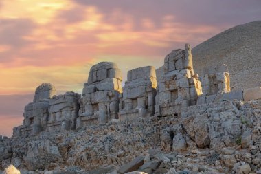 Zeus, Apollo, Herkül ve Aslan 'ın oyulmuş kadim başları, Türkiye' nin güneydoğusundaki antik Commagene Krallığı 'nın arkeolojik bir alanı olan Nemrut Dağı' nın doğu terasında gün batımında.