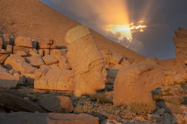 Zeus, Apollo, Herkül ve Aslan 'ın oyulmuş kadim başları, Türkiye' nin güneydoğusundaki antik Commagene Krallığı 'nın arkeolojik bir alanı olan Nemrut Dağı' nın doğu terasında gün batımında.