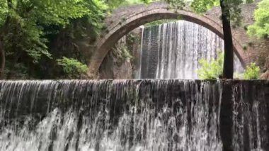 The old stone, arched bridge, between two waterfalls in Palaiokaria, Trikala prefecture, Thessaly, Greece.