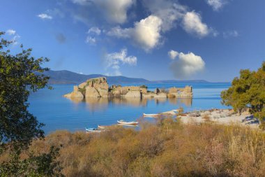 Türkiye 'nin Ege ilindeki Bafa Gölü' nün farklı manzaraları, renkli bir günbatımı ve yansımaları ile manastır ve kaya şekilli rıhtım adaları