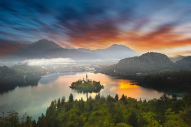 Slovenya 'daki ünlü Alp Bled Gölü (Blejsko jezero), muhteşem sonbahar manzarası. Göl manzaralı, kiliseli ada, Kanlı kale, dağlar ve bulutlu mavi gökyüzü, açık hava seyahati