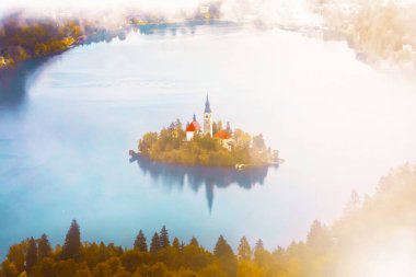 Slovenya 'daki ünlü Alp Bled Gölü (Blejsko jezero), muhteşem sonbahar manzarası. Göl manzaralı, kiliseli ada, Kanlı kale, dağlar ve bulutlu mavi gökyüzü, açık hava seyahati