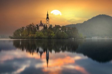 Slovenya 'daki ünlü Alp Bled Gölü (Blejsko jezero), muhteşem sonbahar manzarası. Göl manzaralı, kiliseli ada, Kanlı kale, dağlar ve bulutlu mavi gökyüzü, açık hava seyahati