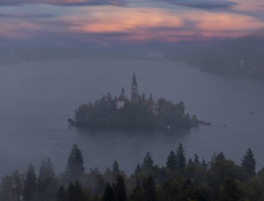 Slovenya 'daki ünlü Alp Bled Gölü (Blejsko jezero), muhteşem sonbahar manzarası. Göl manzaralı, kiliseli ada, Kanlı kale, dağlar ve bulutlu mavi gökyüzü, açık hava seyahati