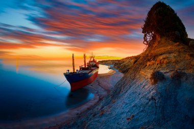 Kıyıya vurmuş bir gemi, gece gündüz fotoğraflanmış.