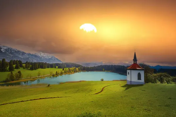 stock image Farm chapel on a small lake ,Lake Hegratsried