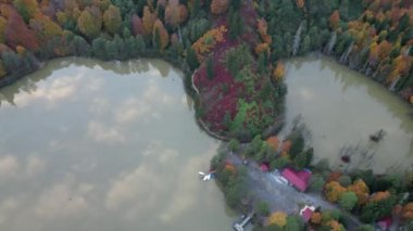 Ağaçlarda sonbahar renkleri. Artvin Borcka Karagl 'ın panoramik görüntüsü uzaktan. Ormanlarla çevrili göl ve gökyüzü.