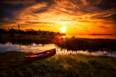 Ulubat Gölü, Golyazi, Bursa, Türkiye 'deki balıkçı tekneleri, büyük ağaç gölleri, gün batımı manzarası