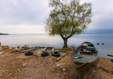 Ulubat Gölü, Golyazi, Bursa, Türkiye 'deki balıkçı tekneleri, büyük ağaç gölleri, gün batımı manzarası