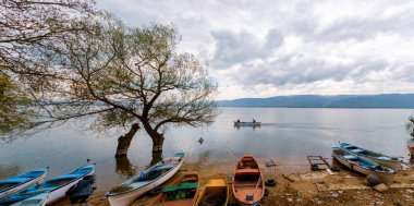 Ulubat Gölü, Golyazi, Bursa, Türkiye 'deki balıkçı tekneleri, büyük ağaç gölleri, gün batımı manzarası