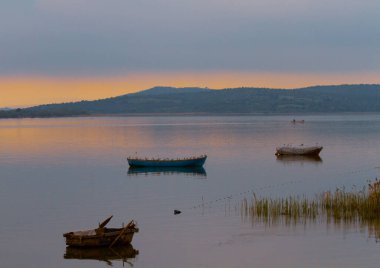 Ulubat Gölü, Golyazi, Bursa, Türkiye 'deki balıkçı tekneleri, büyük ağaç gölleri, gün batımı manzarası