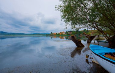 Ulubat Gölü, Golyazi, Bursa, Türkiye 'deki balıkçı tekneleri, büyük ağaç gölleri, gün batımı manzarası